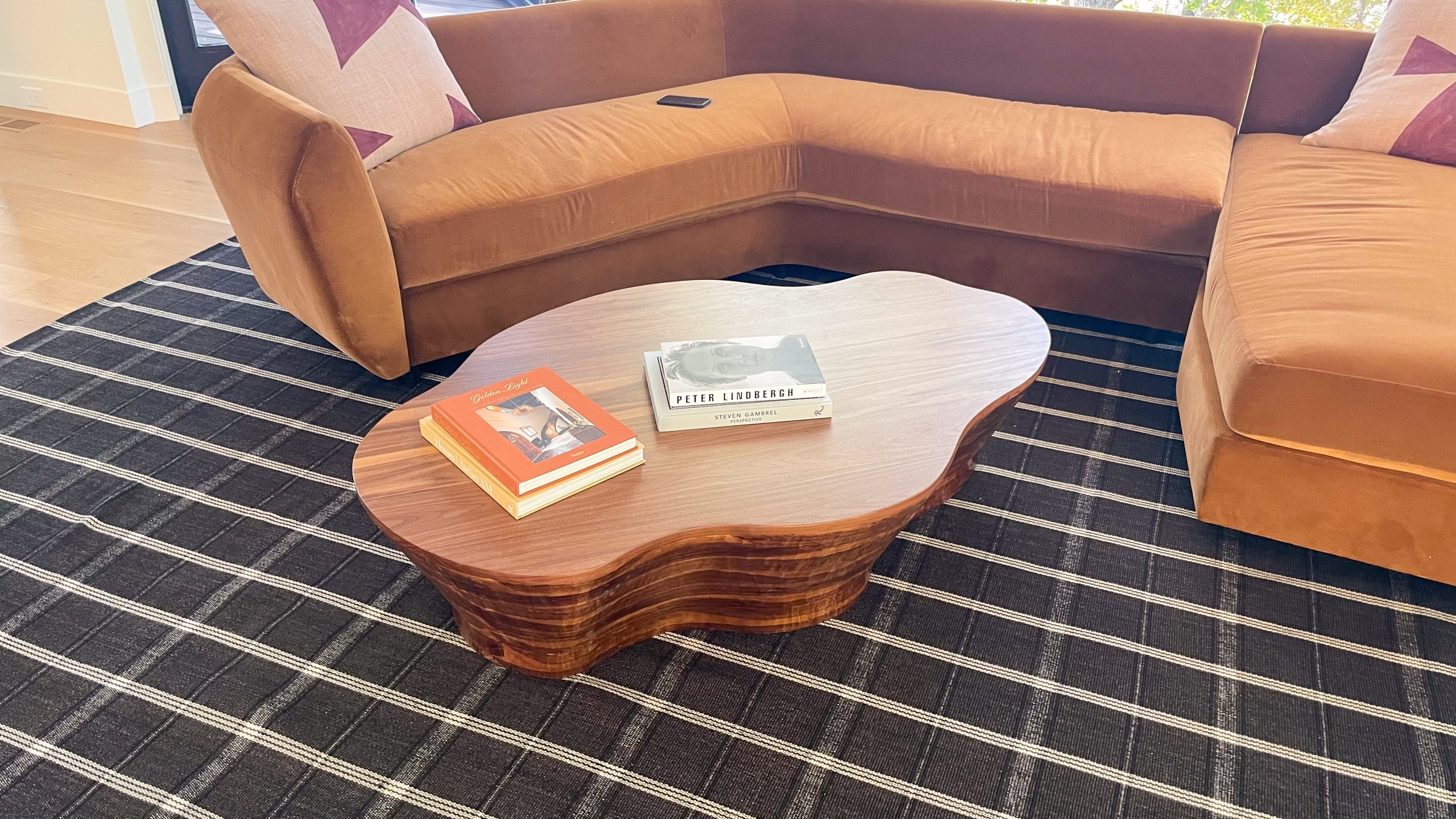 Organic shaped walnut coffee table close up with books