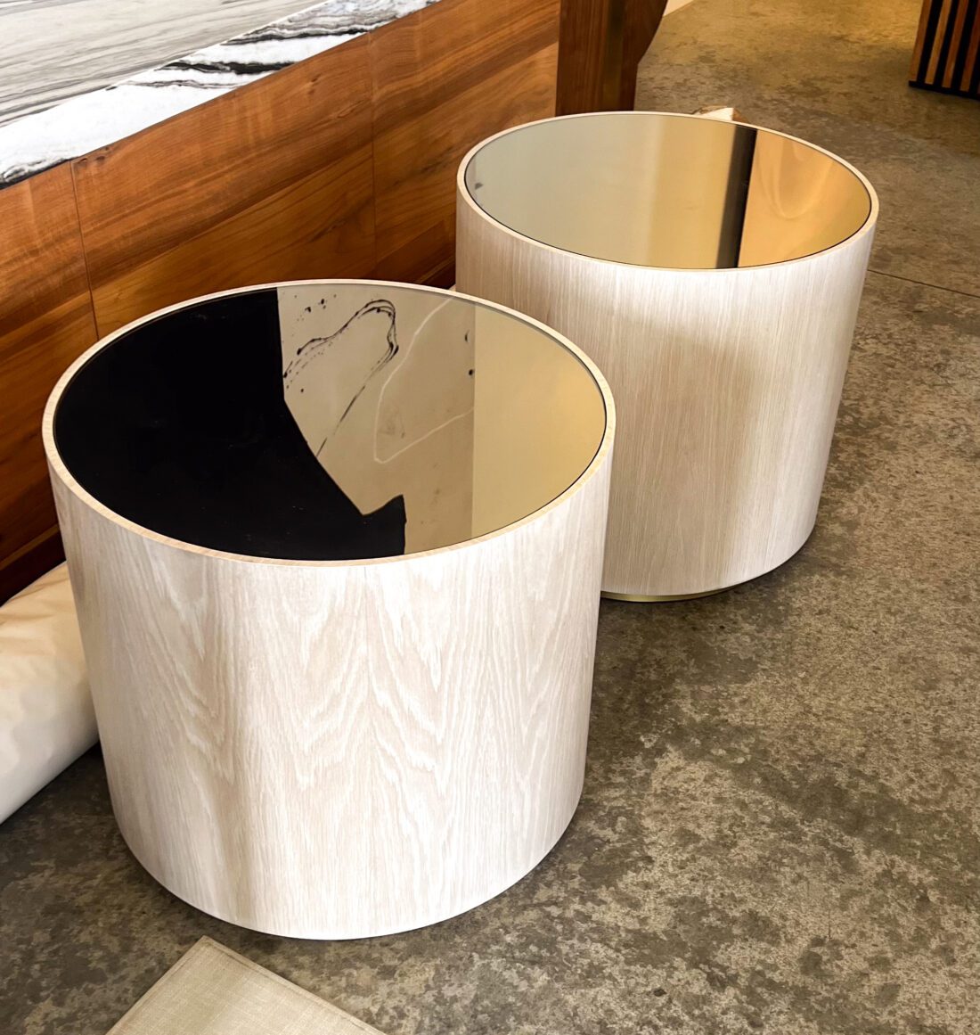 two round end tables with high gloss black toppers inlaid on white oak base with brass trim