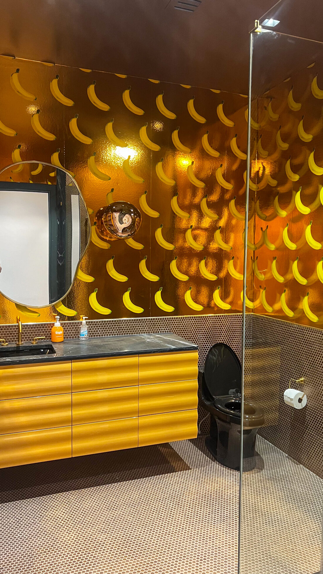 Banana themed bathroom with wavy yellow cabinets