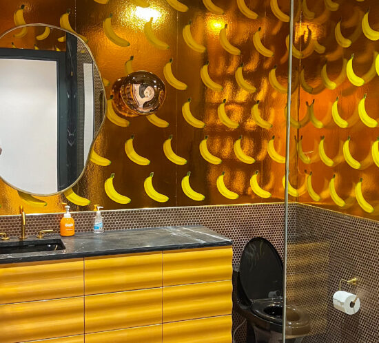 Banana themed bathroom with wavy yellow cabinets