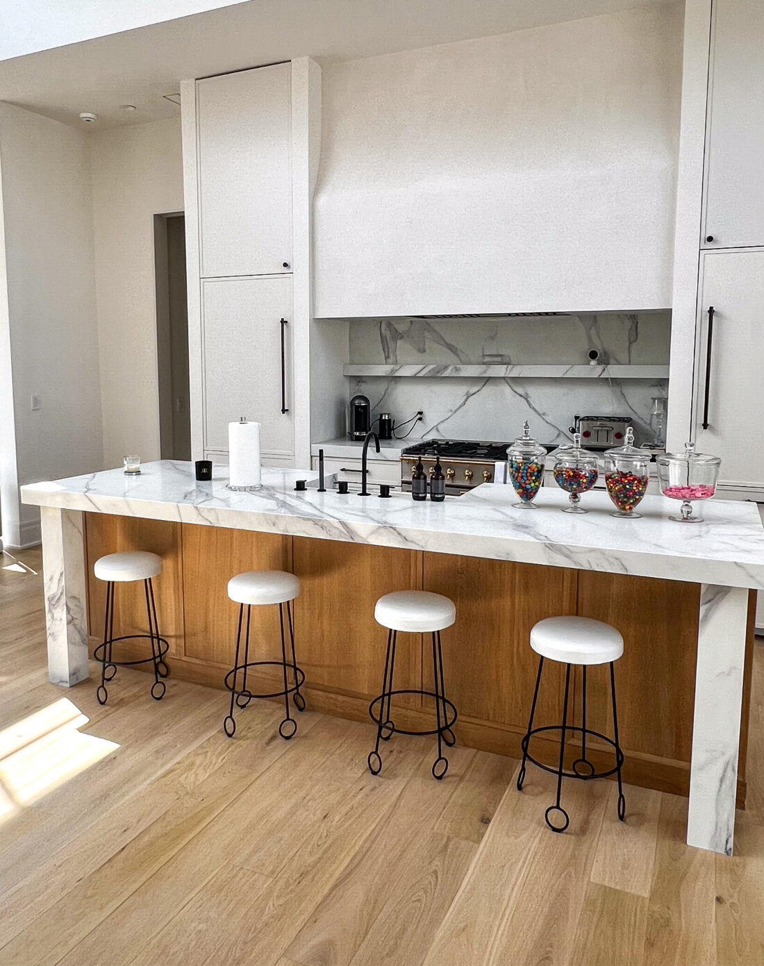 White Marble Cabinetry in home with natural wood island