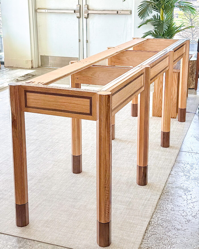 Unfinished wooden table base with walnut inlay and capped legs