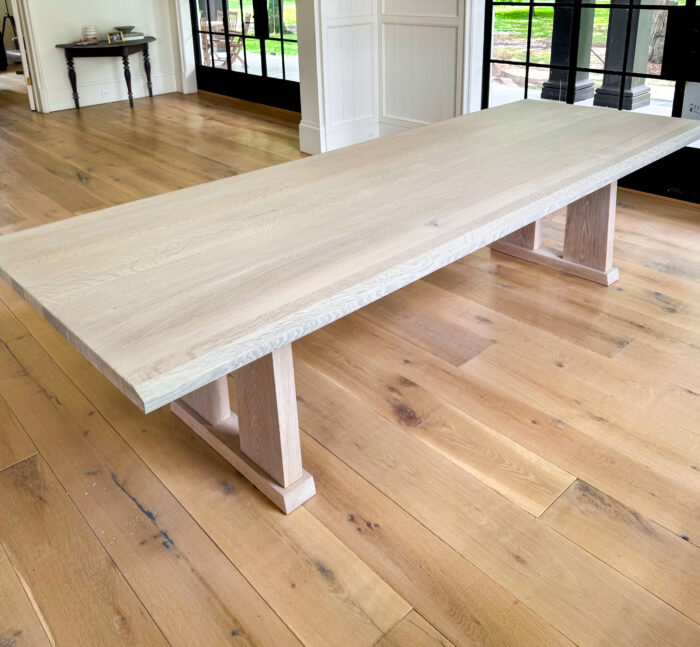 Minimalist white oak dining table with pedestal legs by MDM Design Studio