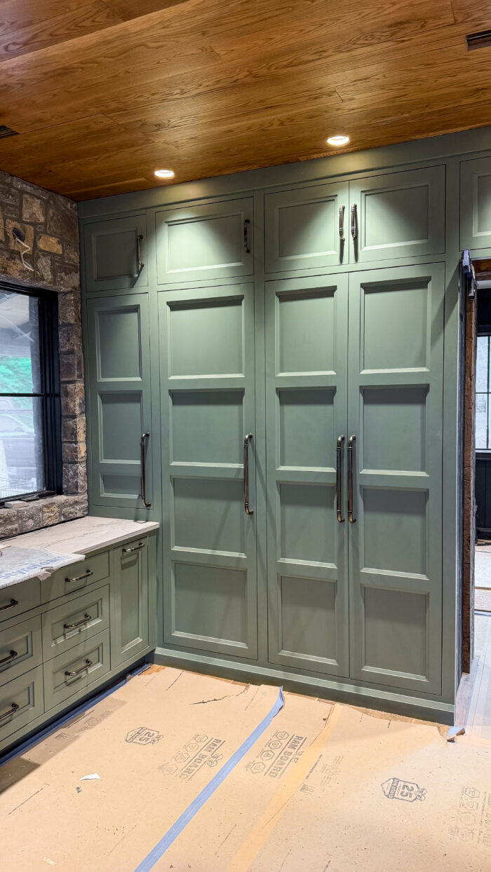 Storage, style, and softness—this sage green cabinet wall does it all.