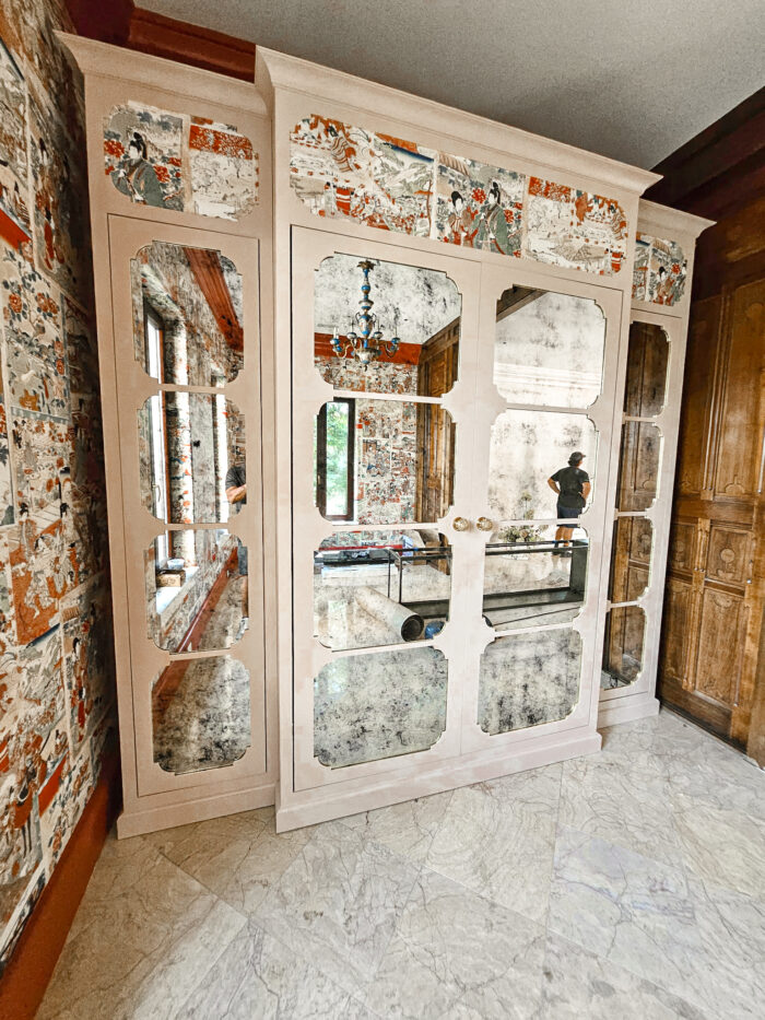 Custom mirrored cabinet with antique-style glass panels framed in a bold wood structure, designed by MDM Design Studio.