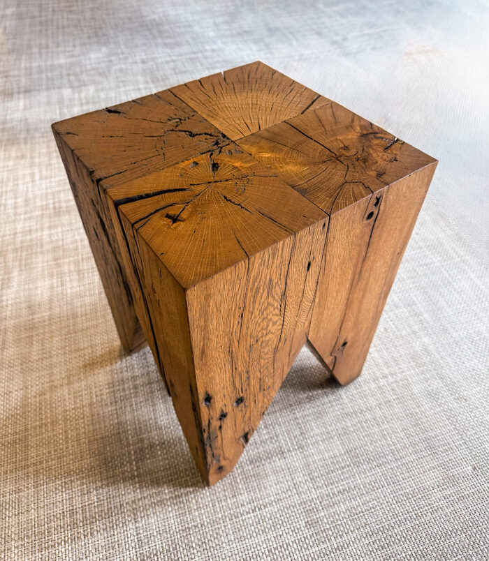 A bold, sculptural stool crafted from reclaimed oak blocks. The natural cracks, knots, and color variation showcase the beauty of aged wood, brought back to life through refined craftsmanship.