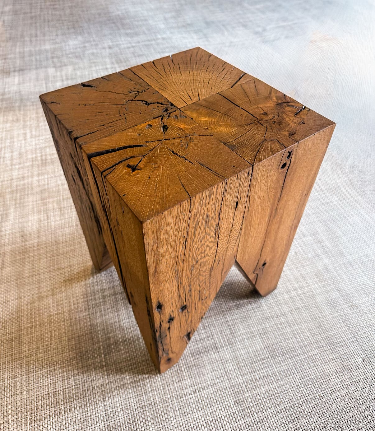 A bold, sculptural stool crafted from reclaimed oak blocks. The natural cracks, knots, and color variation showcase the beauty of aged wood, brought back to life through refined craftsmanship.